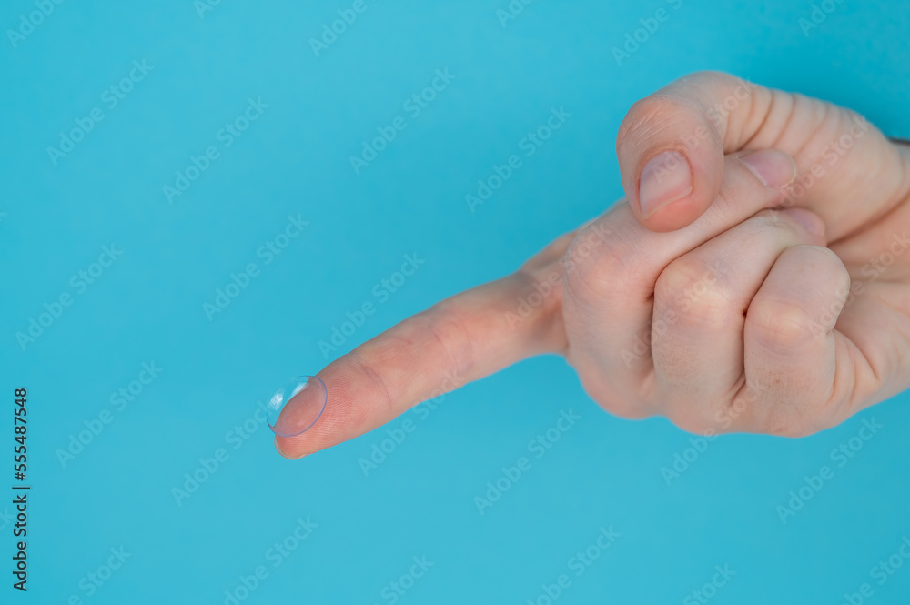 Woman holding contact lens on blue background. Woman holding contact lens on blue background.