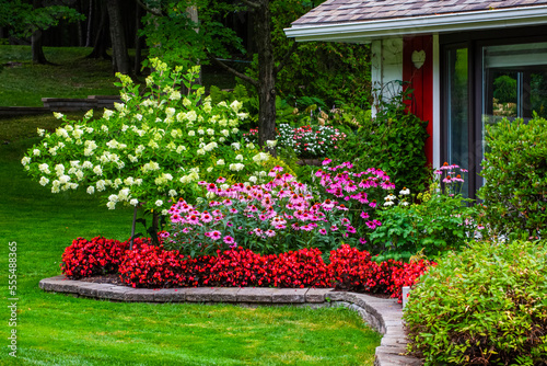 Blossoming flowers decorating the yard of a house; Hudson, Quebec, Canada