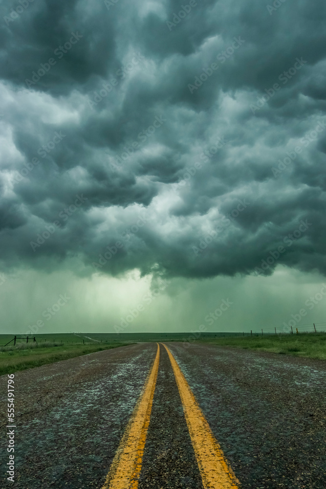 An empty highway disappears into the mouth of a storm somewhere in the Texas Panhandle; Texas, United States of America An empty highway disappears into the mouth of a storm somewhere in the Texas Panhandle; Texas, United States of America