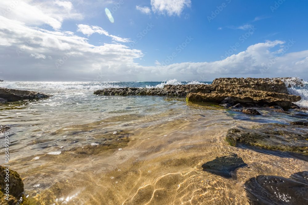 Serene, calm water on Hookipa Beach where surfers and sea turtles fill the beach and the rocks form scenic pools along the beach shore; Paia, Maui, Hawaii, United States of America Serene, calm water on Hookipa Beach where surfers and sea turtles fill the beach and the rocks form scenic pools along the beach shore; Paia, Maui, Hawaii, United States of America