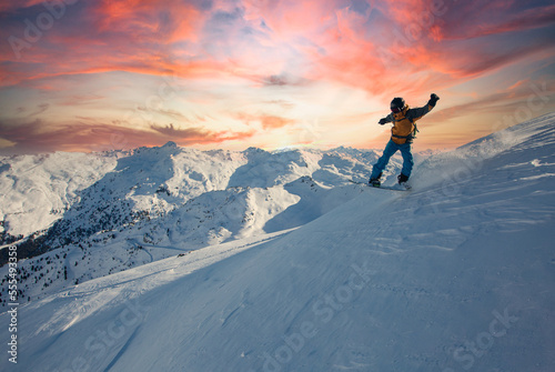 Snowboard rider jumping on a beautiful sunny day in the mountains