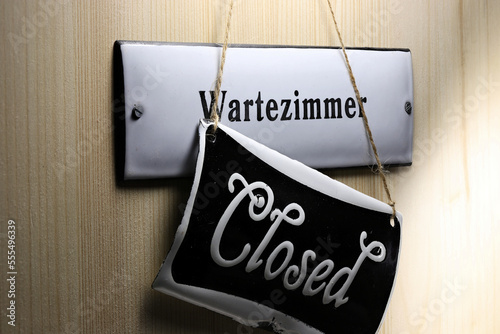 enamel sign on the door to the (closed) waiting room of a German doctor's office photo