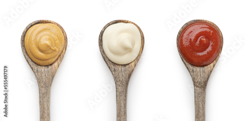 A set of sauces in wooden spoons on a white background photo