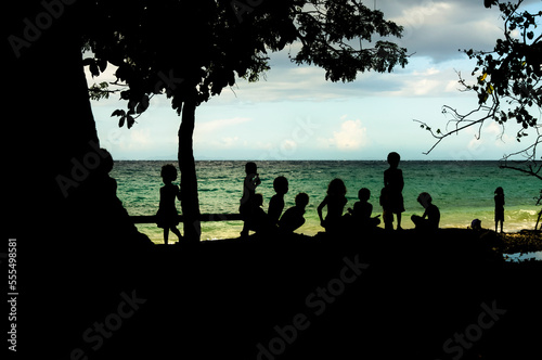 Silhouette of children by a beach, Kakambona Beach; Honiara, Solomon Islands photo