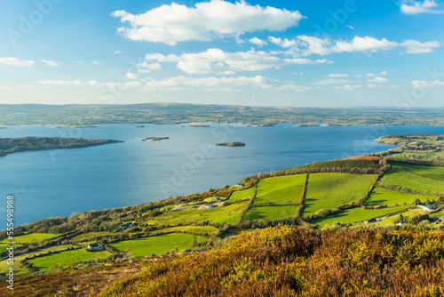 Lough Derg Lake and surrounding countryside with green fields on a blue sky sunny day in summer; Taut, County Tipperary, Ireland photo