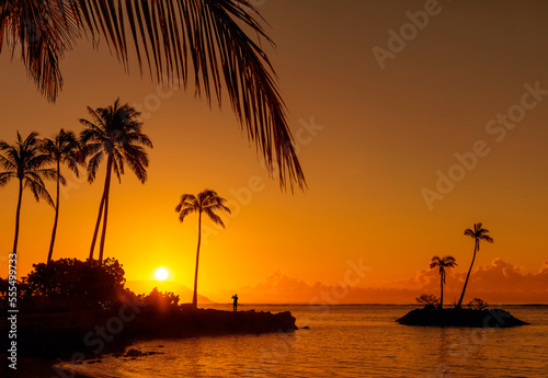 Sunrise at Kahala Beach, Waiʻalae Beach Park, with the sun in a glowing sky reflected in the tranquil water; Oahu, Hawaii, United States of America photo