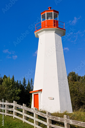 Lighthouse by Fence, Grande Bergeronne, Cote Nord, Quebec, Canada photo