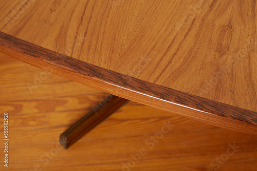 Table, mid-century dining room furniture. Walnut-tone rosewood piece. Close-up detail view. 