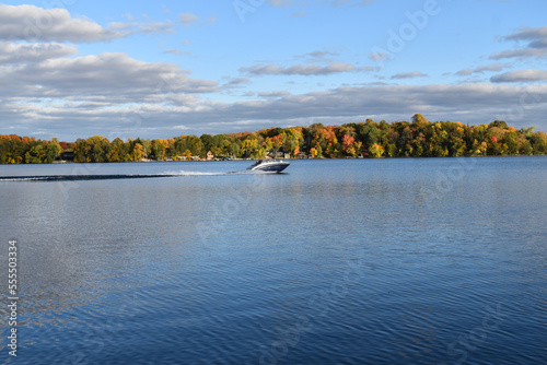 cloudy blue sky over a peaceful minnesota lake with boat photo