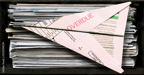 Stack of Unopened Bills with one Folded into Paper Airplane
