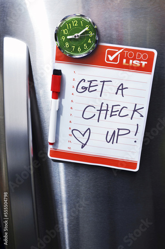 Close-up of Front of Stainless Steel Refridgerator with Magnetized To Do List photo