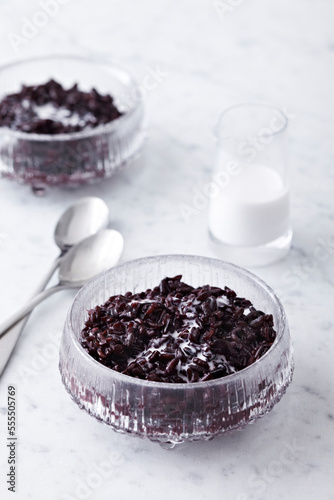 Black Rice Pudding in bowl with coconut milk, studio shot