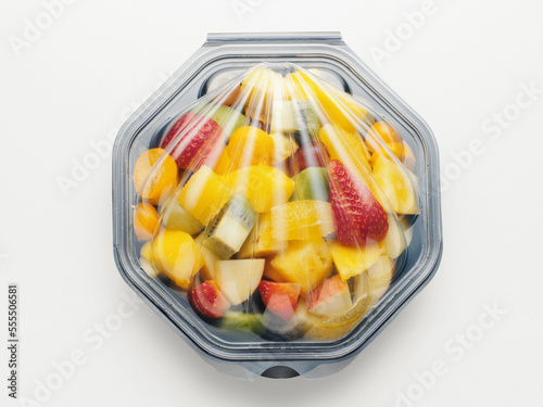 Fruit salad packaged in plastic container, on white background, studio shot photo