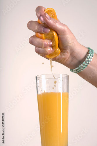 Woman Squeezing Orange, Making Orange Juice