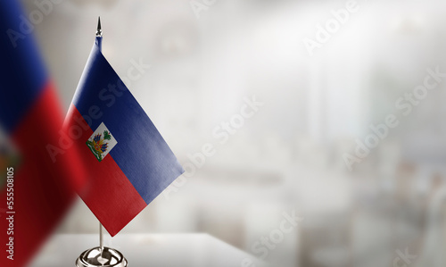 Fotografiet Small flags of the Haiti on an abstract blurry background