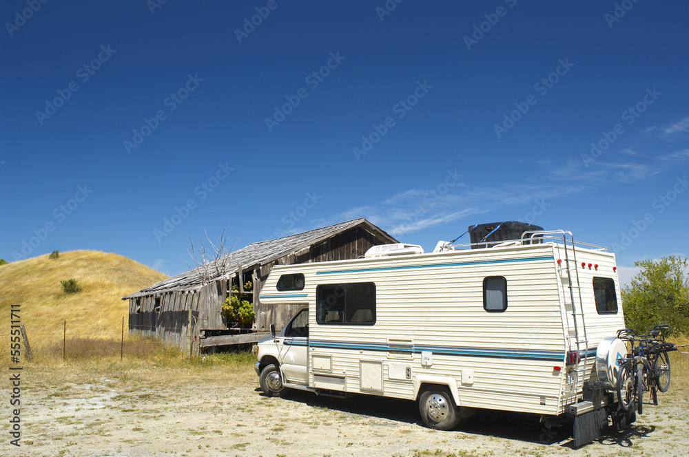 Recreational Vehicle Parked by Abandoned Building Recreational Vehicle Parked by Abandoned Building