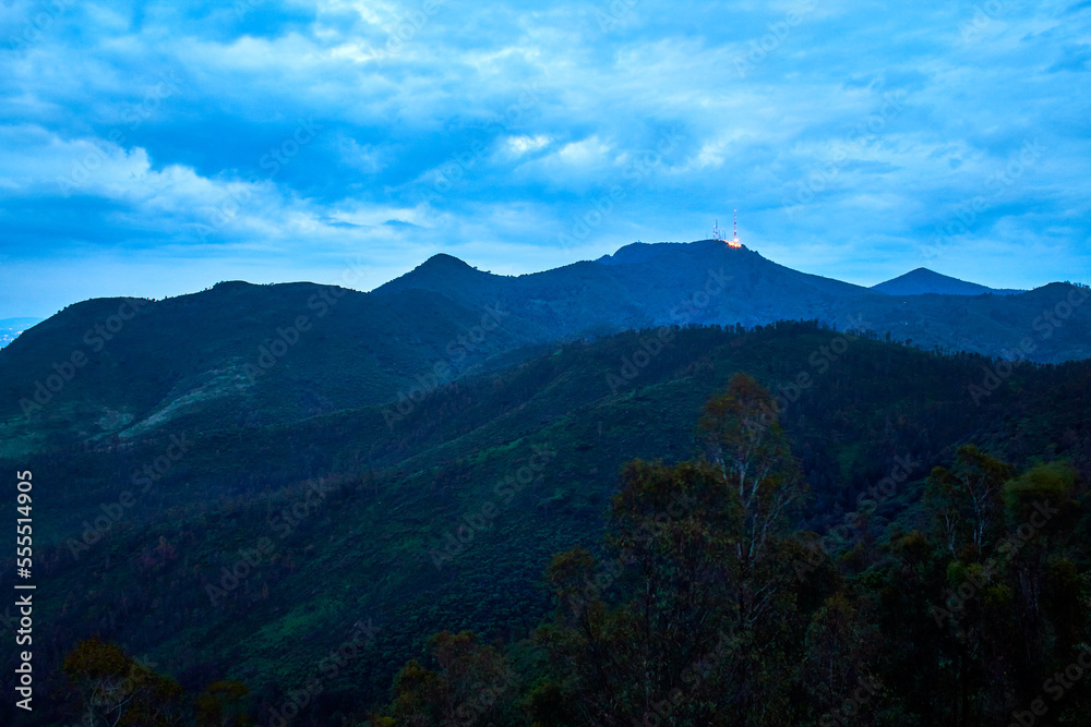 green mountains in blue hour in rainny day with cloud sky, antenna in top of mountain, sierra de guadalupe state of mexico green mountains in blue hour in rainny day with cloud sky, antenna in top of mountain, sierra de guadalupe state of mexico