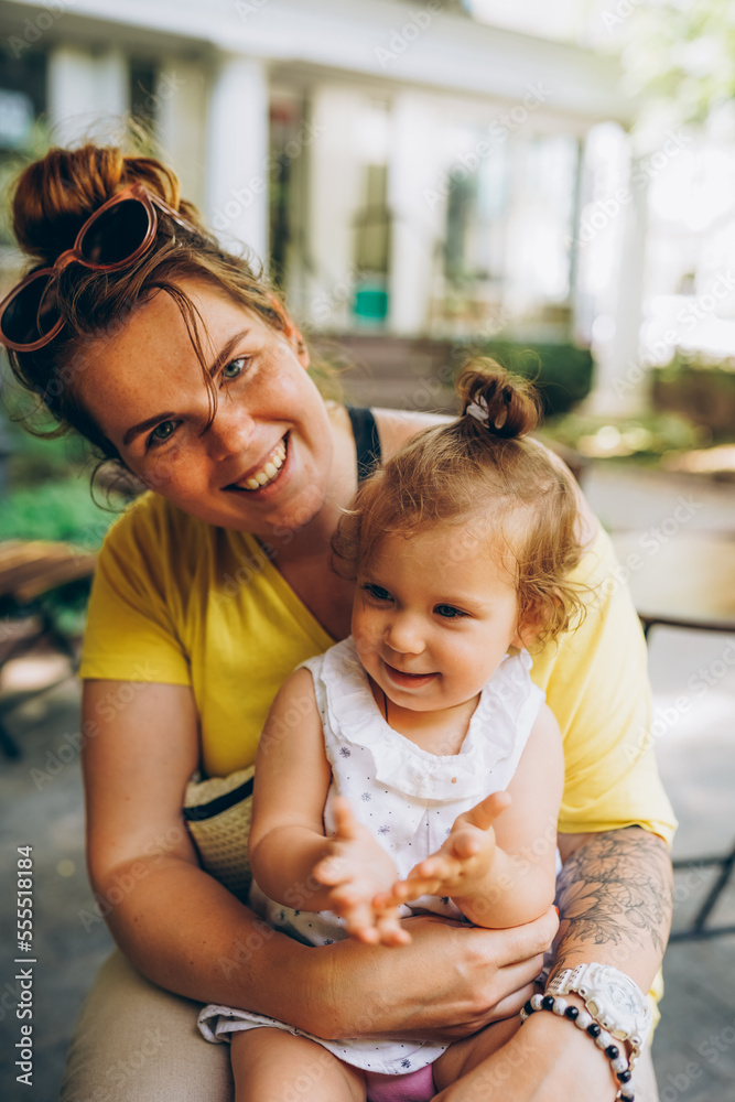 Happy mother and daughter laughing together outdoors