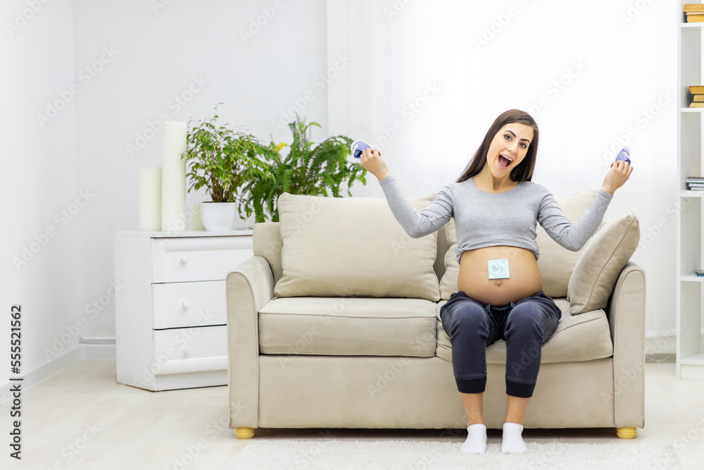 Photo of pregnant woman holding a paper with sex of the child. Photo of pregnant woman holding a paper with sex of the child.