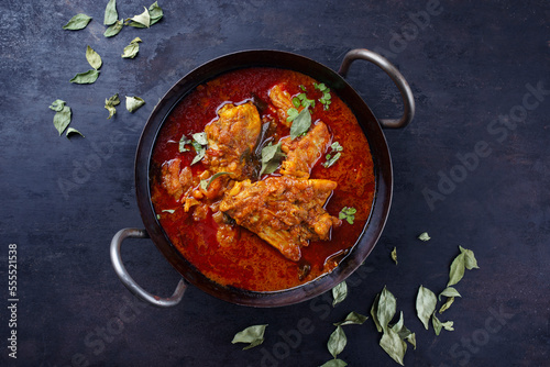 Traditional spicy Indian chicken Madras curry Rogan Josh with drumsticks and wings served as close-up in a korei bowl