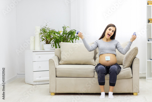 Photo of pregnant woman holding a paper with sex of the child.