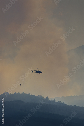 Smoke from Forest Fire with Fire Fighting Helicopter photo