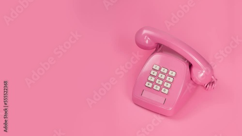 Pink push-button phone ringing stop motion on pink background With place for text on the left Horizontal frame