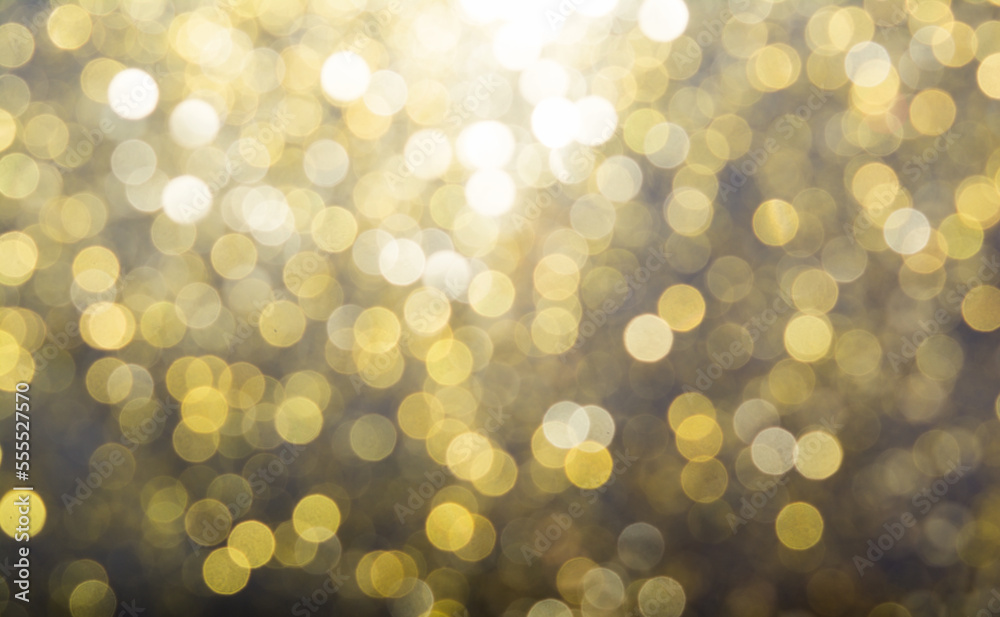 Obraz premium Abstract blurred glitter bokeh background in gold, on black