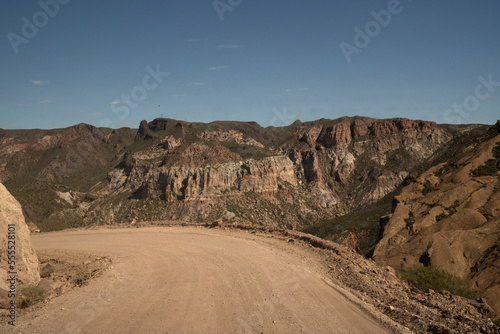 Travel. View of the dirt road across the arid desert and mountains.