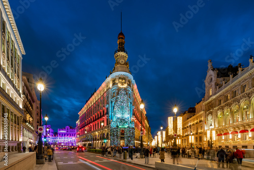 Cruce de las Calles Sevilla y Alcalá con el Edificio Canalejas adornado con elementos navideños en el centro, albergando las Galerías Canalejas y un Hotel Four Seasons.