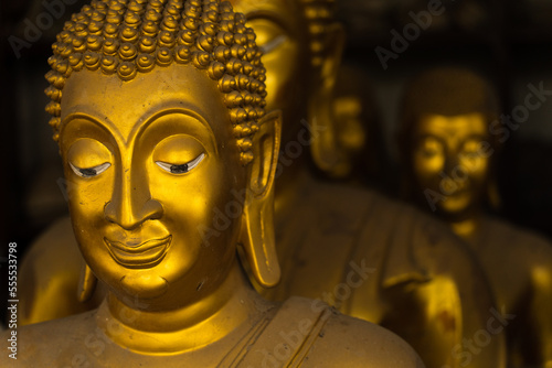 Closeup image of buddha's face statue with other buddha statues as background. This photo represents the concept of meditation, peaceful, calm, religious and meditation.
