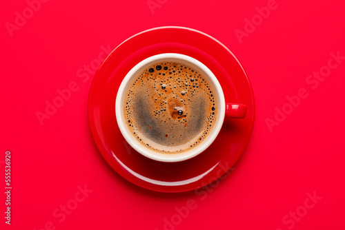 Cup of coffee with plate on red background