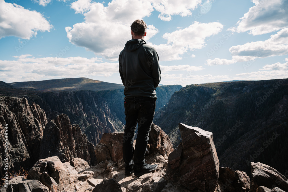 Hiker overlooking black canyon in Colorado - Hiking, environment, sustainability, landscape