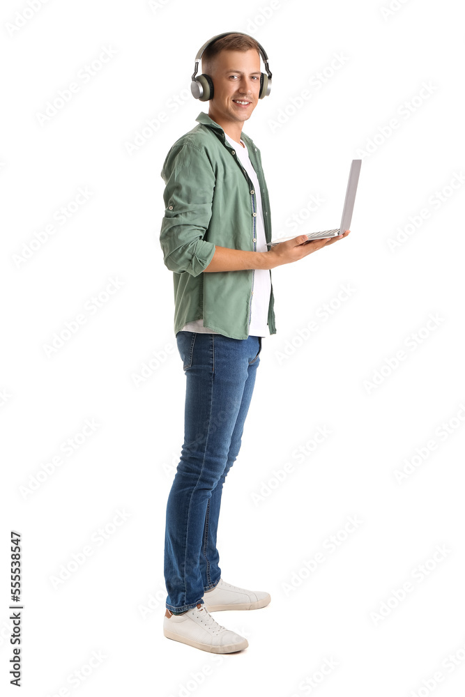 Young man with headphones and laptop studying online on white background