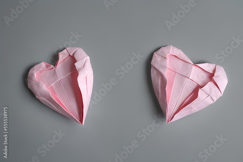 Two pink origami hearts on gray background