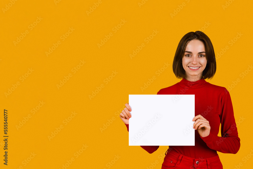 Cheerful young woman showing white blank advertising board Cheerful young woman showing white blank advertising board