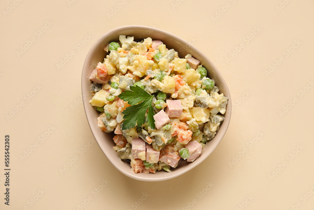 Bowl of delicious Olivier salad on color background Bowl of delicious Olivier salad on color background