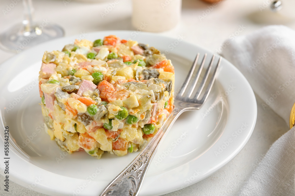 Plate of tasty Olivier salad on light table, closeup Plate of tasty Olivier salad on light table, closeup