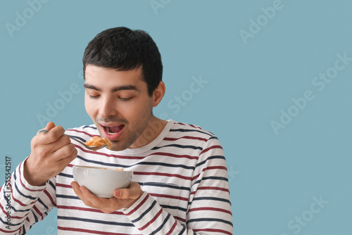 Young man eating cornflakes...