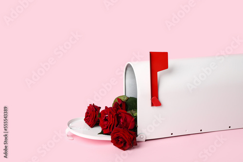 Mailbox with red roses on pink background. Valentine's Day celebration