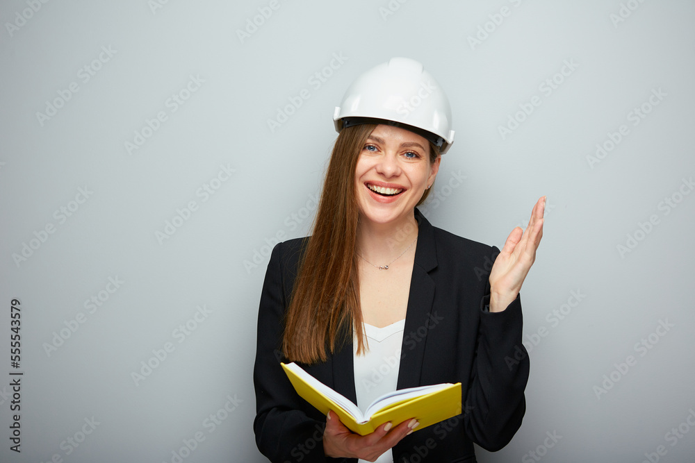 Woman student or teacher in safety helmet holding book. Woman student or teacher in safety helmet holding book.