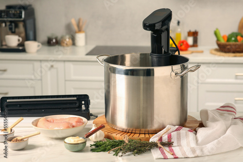 Bilde på lerret Thermal immersion circulator in pot, sealer for vacuum packing and ingredients on table in kitchen