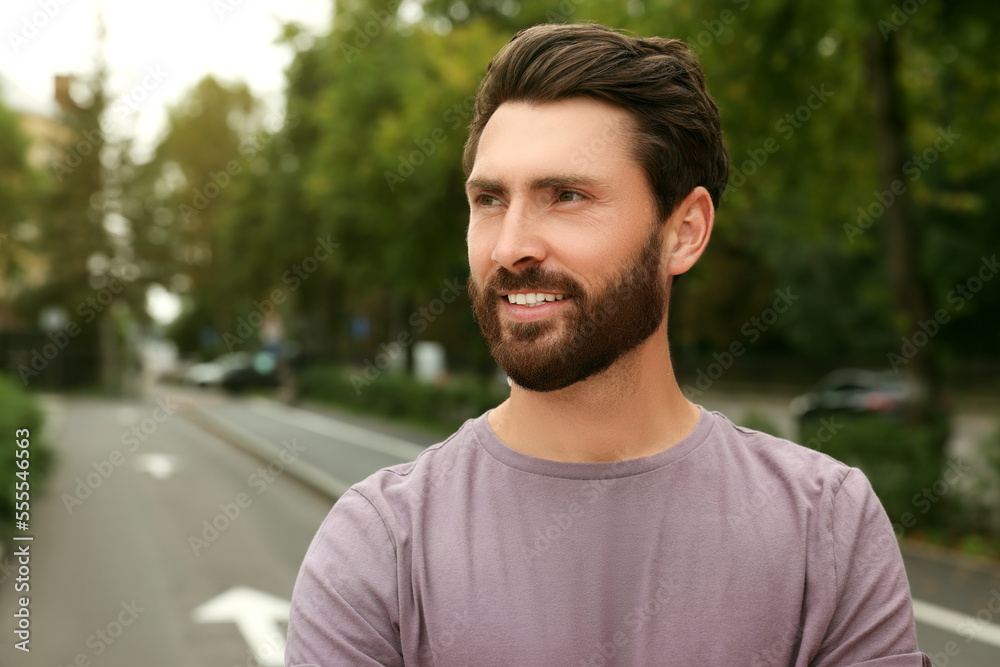 Portrait of handsome bearded man on street, space for text