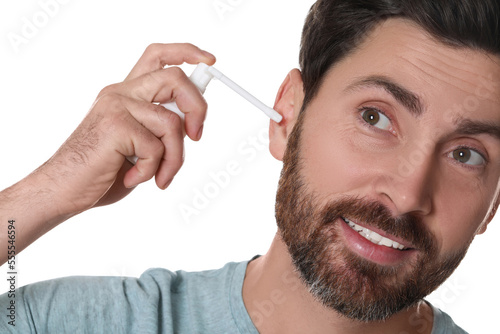 Man using ear spray isolated on white, closeup