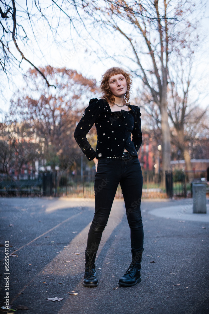 portrait of woman with red hair and freckles in urban park portrait of woman with red hair and freckles in urban park