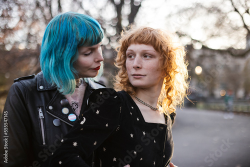 unconventional lesbian couple embrace in park at sunset
