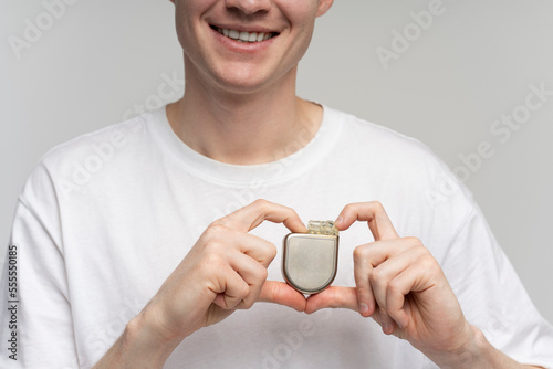 Caucasian man holding Implantable cardioverter defibrillator (ICDs) and smiling toothy photo