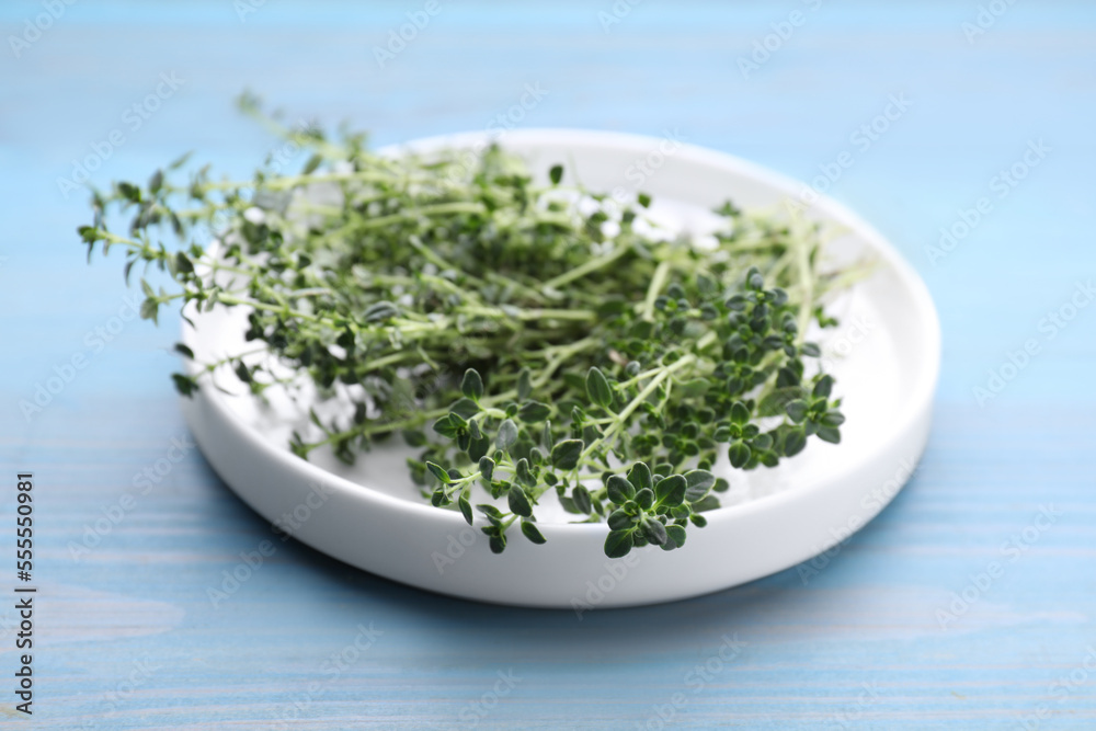 Bunch of aromatic thyme on light blue wooden table, closeup. Fresh herb Bunch of aromatic thyme on light blue wooden table, closeup. Fresh herb