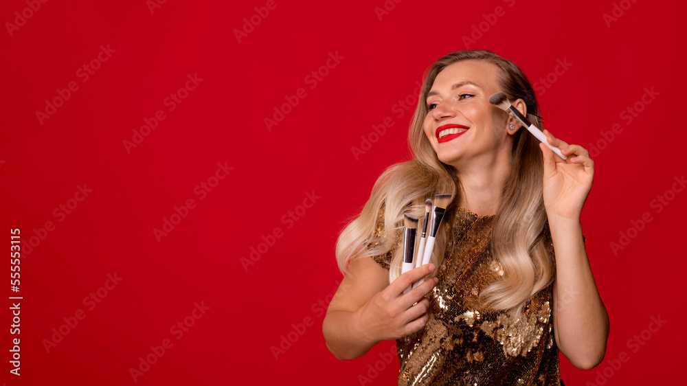 bright makeup artist with brushes on red background. portrait of woman with brushes applying makeup on face bright makeup artist with brushes on red background. portrait of woman with brushes applying makeup on face