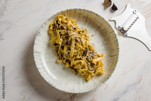 tagliatelli pasta with black truffle on marble table top view photo